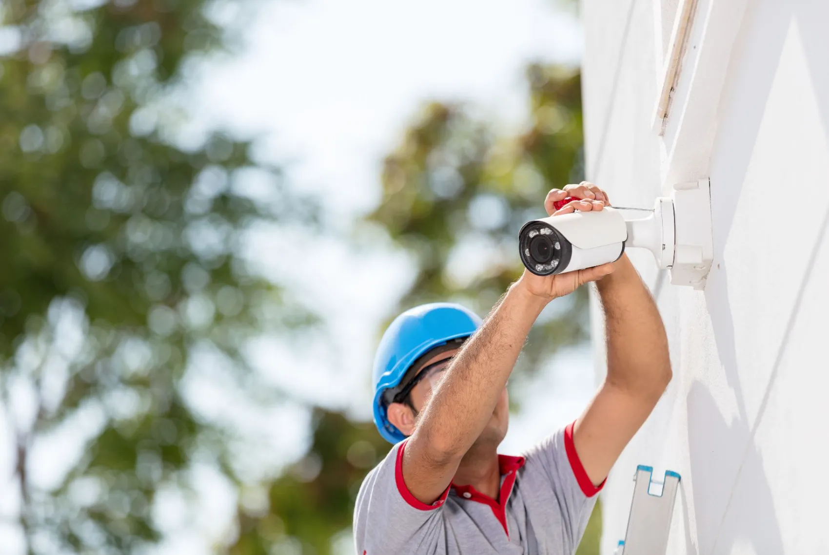 WE TECH technician installing an outdoor security camera